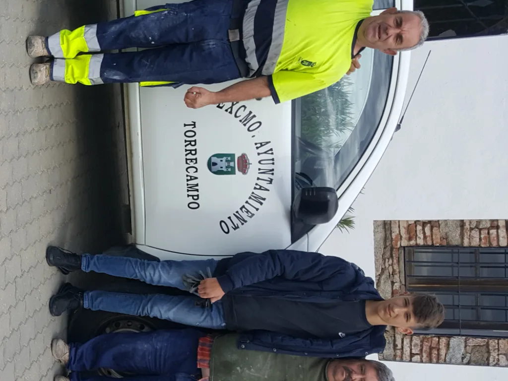 Zwei Personen in Warnkleidung arbeiten an einem Fahrzeug der Gemeinde.